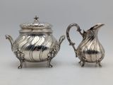 a pair of silverplated teapots and a creamer