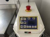 a white machine with a red button on top of it