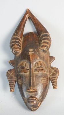 an image of a wooden mask with horns on a white background