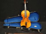 un violon et un étui à violon posés sur une surface noire