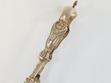 an antique silver plated spoon with a handle on a white surface
