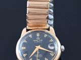 a close up of a wrist watch on a black surface