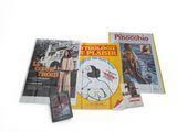 several books on a white surface with pictures of people on them