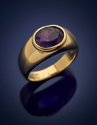 a gold ring with a purple stone in the center
