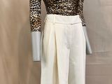 the mannequin is wearing a leopard print top and white skirt