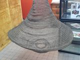 a wicker hat hanging from the ceiling in a store