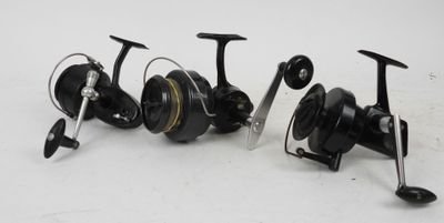 a couple of fishing reels sitting next to each other on a white surface