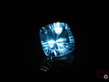 a close up of a blue diamond on a black surface