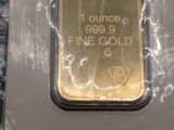 un gros plan sur un lingot d'or dans un emballage posé sur une table