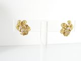 a pair of gold toned earrings with leaves and pearls