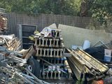 un tas de vieilleries dans un jardin, près d'une clôture