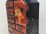 a black and red chest of drawers with flowers on it