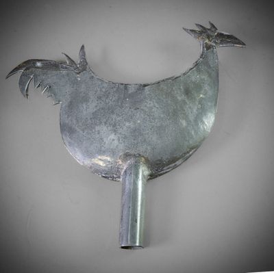 a metal fan with a bird on top of it