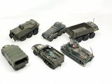 several toy army vehicles are lined up in a row on a white surface