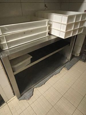 sol carrelé dans des toilettes publiques équipées d'un lavabo et d'étagères