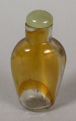 a yellow glass vase with a green lid