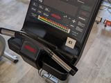 a gym room with tread machines and a monitor on the wall