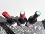 three bottles of wine sitting on a marble table