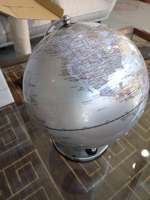un globe blanc posé sur une table en verre dans un salon