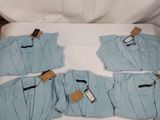 quatre paires de pyjamas bleus pour homme posées sur un lit blanc