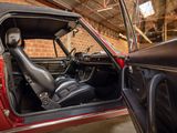 a red car with a black seat in a garage