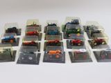 de nombreux tracteurs miniatures dans des boîtes en plastique, posés sur une surface blanche