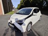 une petite voiture blanche garée sur le bord de la route