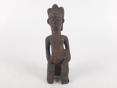 an image of a statue of a person sitting on a white surface