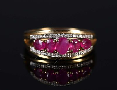 a close up of a gold ring with ruby stones and diamonds
