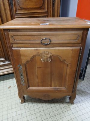 a wooden cabinet that has a drawer on top of it