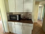 a kitchen with white cabinets and a microwave on the counter