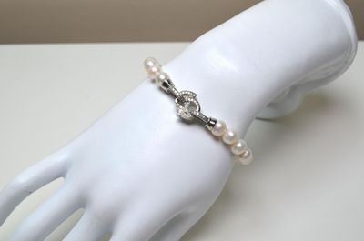 Un bracelet en perles de culture avec fermoir serti de pierr…