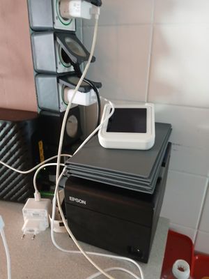 une petite imprimante posée sur une table, à côté d'un téléphone portable