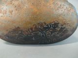 a brown vase with writing on it sitting on a table