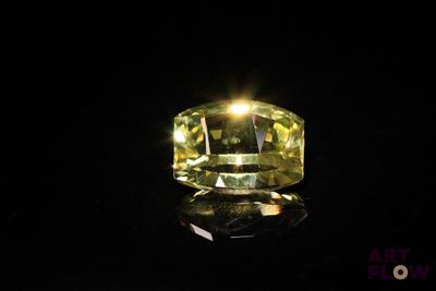 gros plan d'un diamant jaune sur une surface noire