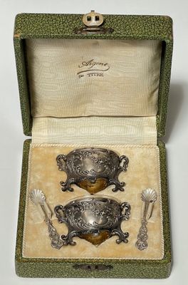 deux cuillères plaquées argent dans un coffret contenant une cuillère et un repose-cuillère