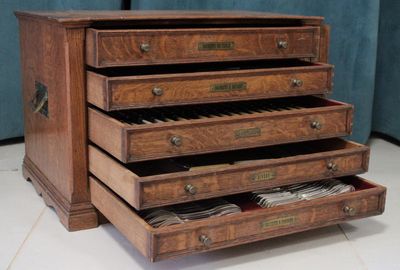 a wooden chest of drawers that has a bunch of papers in it