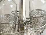 a silver tray with two glass bottles and a candle holder on it