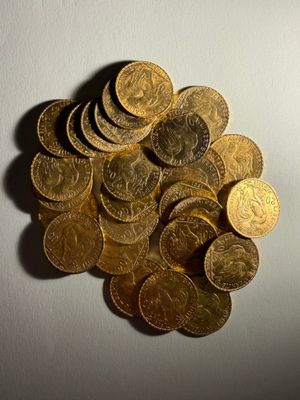 une pile de pièces d'or posée sur une surface blanche