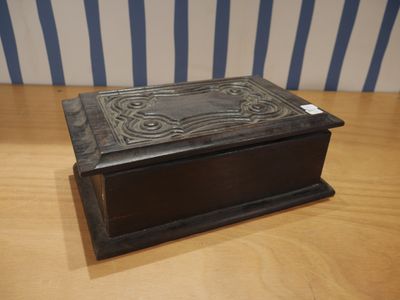 un vieux livre posé sur une table en bois, près d'un mur rayé
