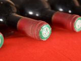 several bottles of wine are lined up on a red table