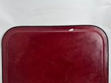 a red tray sitting on a white surface next to a cup