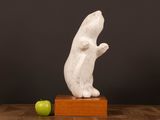 an image of a sculpture of a rat on a wooden block next to an apple