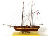 une maquette de voilier posée sur un socle jaune