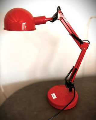 une lampe de bureau rouge posée sur une table