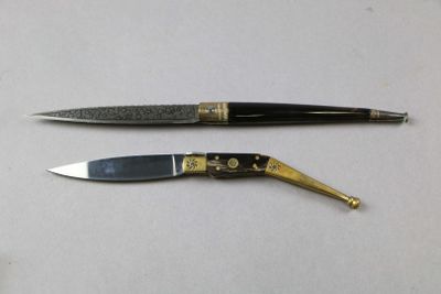 two different types of knives on a white surface
