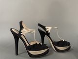 pair of black and white high heeled shoes with a bow on the toe