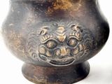 a metal bowl with a face on it
