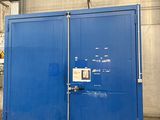 un grand conteneur bleu posé au milieu d'un parking