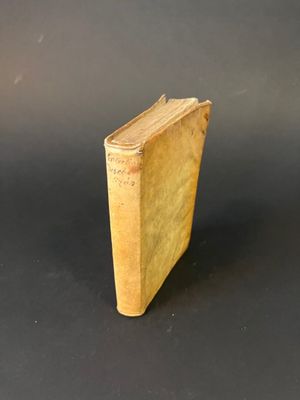 an old book sitting on top of a table next to a black background